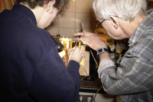 Me and my dad close together to desolder the multi-cap in the Ampeg R12A, with 2 soldering irons and extra light