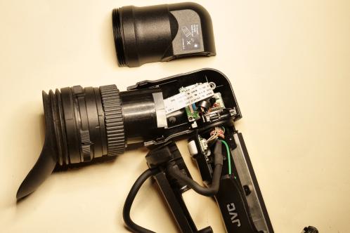 A JVC GY-HM750 viewfinder with almost all of its housing removed, with the flatcable and other electronics visible