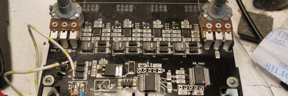 Een zwarte print met diverse SMD IC's, weerstanden, condensatoren, diodes en twee flinke potmeters, de regelprint van een Tristar 4 ledlamp