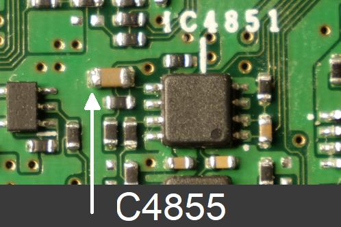 Een zwart op-amp SMD IC en diverse andere SMD componenten op een groene printplaat, het analog board van een JVC-GY-HM100 videocamera