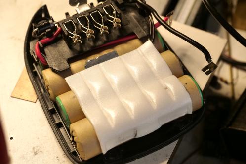 De cilindrische accu-cellen van een Bosch PSR lithium schroefmachine-accu met wit schuim en aansluitklemmen in meer detail