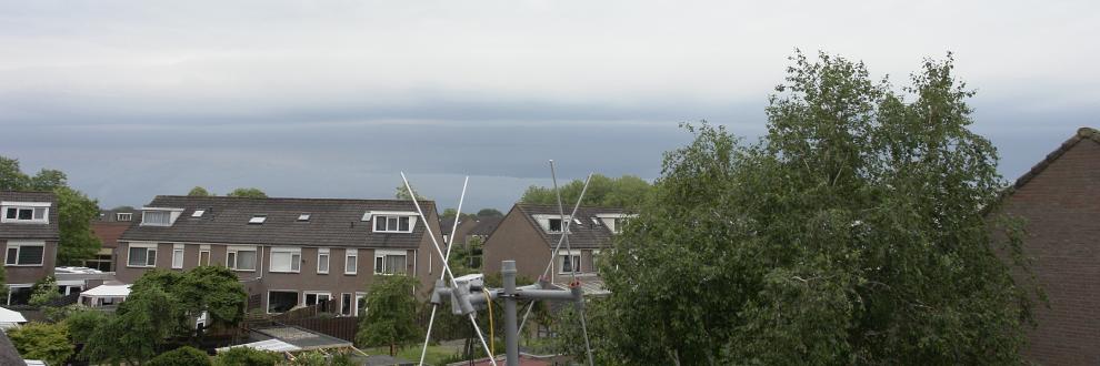 Vrijwel onbewolkt boven mij en een donkere lucht in aantocht in de verte van naderende onweersbui