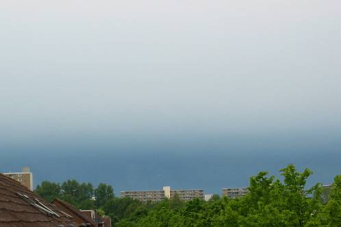 Naderend onweer boven Purmerend met scherpe scheiding in de lucht tussen licht en donker