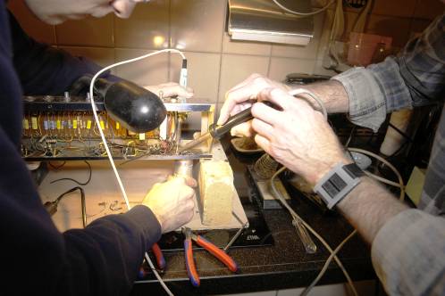 Me and my dad close together to desolder the multi-cap in the Ampeg R12A, with 2 soldering irons and extra light
