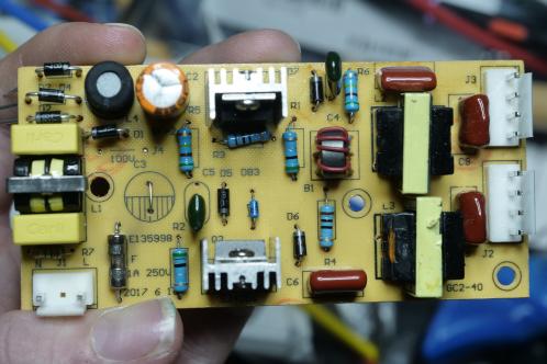 Een geel gekleurde electronica-printplaat met condensatoren, weerstanden, transistoren en enkele transformators, de TL-buis module van een Knock Off Insect Killer vliegenlamp