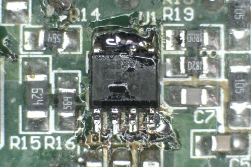 Een microscoopfoto van een groene elektronicaprint met een IW3689-01 SOIC-8 IC waarvan de pinnen 5 tot en met 8 met 1 grote klodder tin met elkaar verbonden zijn ter verwijdering van het IC