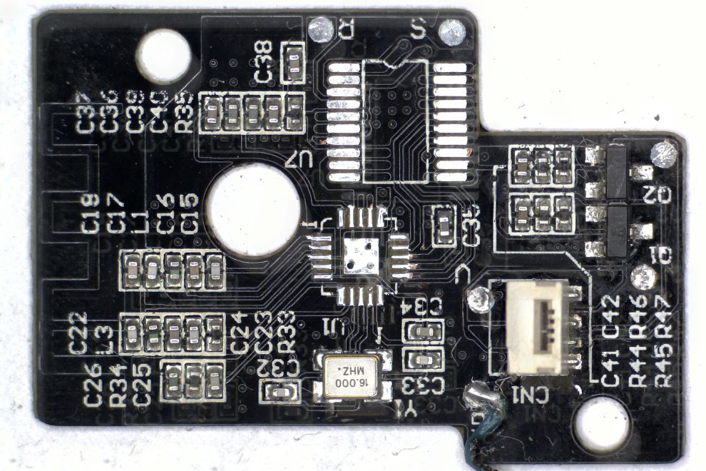 Een zwarte printplaat met SMD-onderdelen in 0402 formaat, een klokoscillator, twee transistors in SOT23 formaat en connector ter verbinding van de print met de hoofdprint, maar met het A7105 en STM8L051F3 controller verwijderd in een grote afbeelding gemaakt met de microscoop ter controle van onderdelen en printsporen