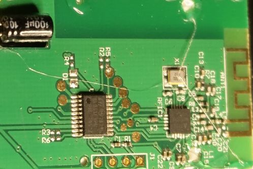 Een groene printplaat met voornamelijk SMD-onderdelen in diverse afmetingen, twee IC's en een klok-oscillator, de printplaat van een 2,4 GHz radio-afstandsbediening voor een Patona DMW-BGGH5RC batterygrip